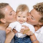 female couple kissing a child