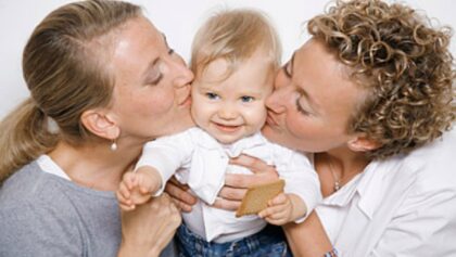 female couple kissing a child